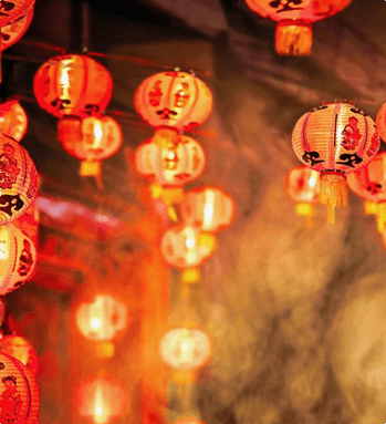 A bunch of red and yellow lanterns hanging from the ceiling.