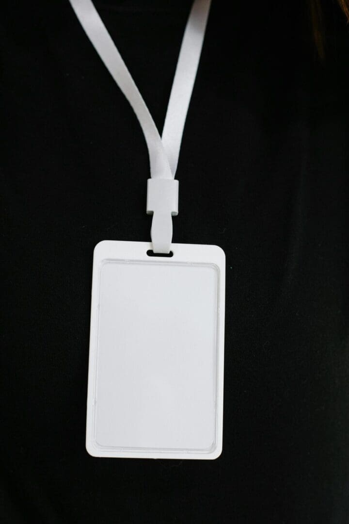 A white plastic tag with two cords attached to it.