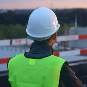 A man in yellow vest and white hard hat.