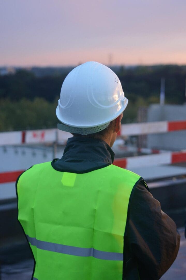 A man in yellow vest and white hard hat.